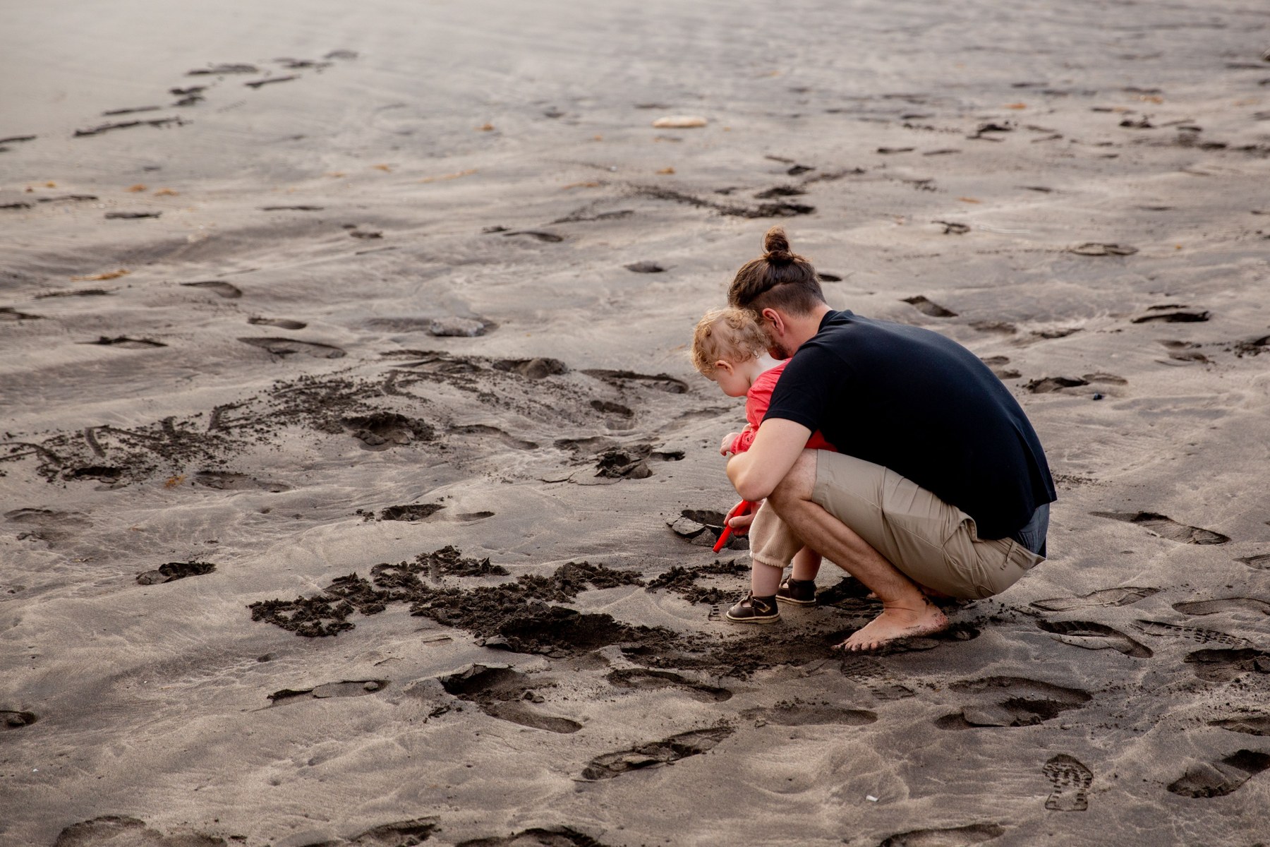 Un padre comparte un momento de juego con su hijo en la playa. Imagen ilustrativa.